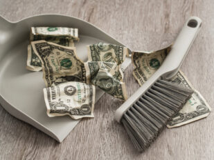 dustpan and brush sweeping up dollar bills