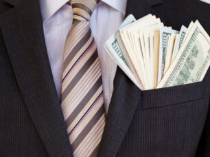 close up of man in suit with money in his suit jacket pocket