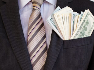 close up of man in suit with money in his suit jacket pocket